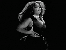 a woman with curly hair is wearing a choker and a black top