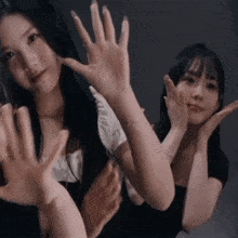 two women are making funny faces with their hands in the air
