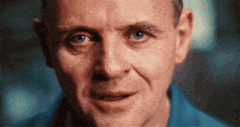 a close up of a man 's face in a blue shirt