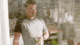 a man is holding a glass of wine while standing in a kitchen .