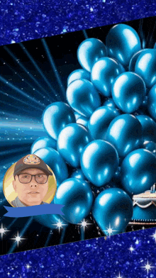 a bunch of blue balloons with a man 's face in the center