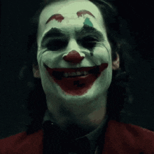 a close up of a man with a clown face painted on his face .