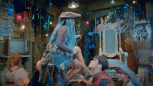 a man is holding a woman in his arms in a room with a sign that says pride and thirst on it