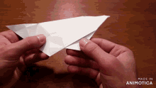 a person is holding a piece of paper that says made in animonica