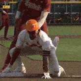 a baseball player wearing an orange helmet with a letter t on it