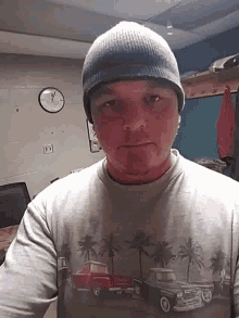 a man wearing a beanie and a t-shirt with cars on it