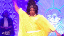 a woman in a yellow polka dot dress is dancing on a stage with the words jordan thus written below her
