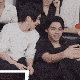 a group of young men are sitting on a couch laughing