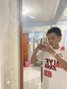 a man taking a picture of himself in a mirror wearing a jersey with the number 30