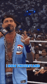 a man wearing a blue cubs jersey is standing in a boxing ring
