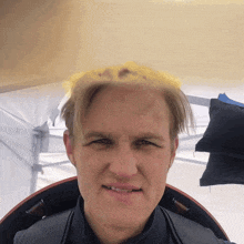 a man with a crown on his head is smiling for the camera