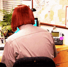 a woman is sitting at a desk with a telephone and a map on the wall