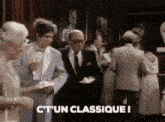 a group of people standing in a room with the words c ' un classique ! written on the bottom .