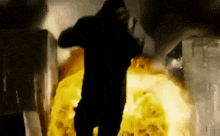 a silhouette of a man standing in front of a fire