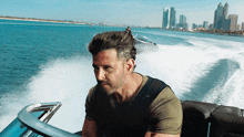 a man in a green shirt is driving a boat in the ocean