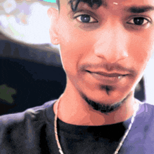 a close up of a man 's face with a beard and a necklace