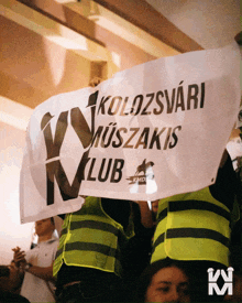 a group of people holding a sign that says kolozsvári muszakis klub