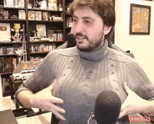 a man wearing a turtleneck sweater is standing in front of a microphone with thinkjules written on the bottom