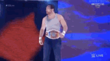 a man wearing a wrestling belt is walking down a ramp .