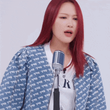 a woman singing into a microphone wearing a jacket that says t9 t9 t9