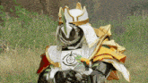 a man in a samurai costume is standing in the grass holding a sword