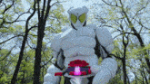 a white robot with a red belt is standing in a park