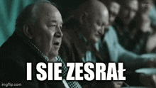 a group of men are sitting at a table and one of them is saying `` i sie zesrai '' .
