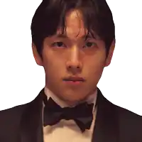 a man in a tuxedo with a bow tie looks at the camera