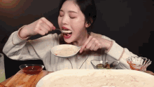 a woman is eating a large amount of food with a ladle