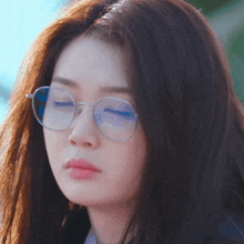 a close up of a woman wearing round glasses
