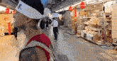 a man with a tattoo on his arm is walking down a street wearing a headband .