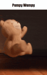 a teddy bear is being held in someone 's hand and says pumpy wumpy on the bottom