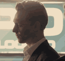 a close up of a man 's face in front of a sign that says ' logo '