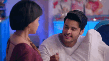 a man and a woman are sitting next to each other and smiling