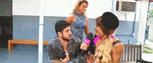 a man and a woman are sitting at a table with a microphone .