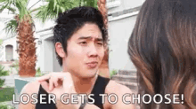 a man is pointing at a woman and says `` loser gets to choose '' .