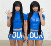 two women wearing blue tops and skirts that say four our