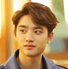 a close up of a young man 's face wearing a blue shirt and a blue jacket .