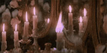 a bunch of candles are lit in front of a mirror .