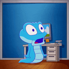a blue cartoon character is sitting at a desk with a computer in the background