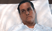 a man in a hospital gown is laying on a bed