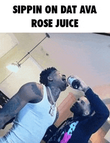 two men are drinking rose juice from a bottle in a living room .