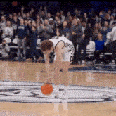 a basketball player on a court with the word butler on the wall behind him
