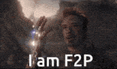 a man is holding something in his hand with the words i am f2p written on it .
