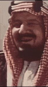 a man with a beard is wearing a red and white scarf around his head .