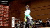 a woman stands in a ring with a sign that says nft lab