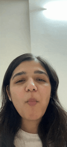 a close up of a woman 's face with a white shirt on