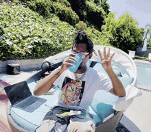 a man sitting on a couch drinking from a cup with a picture of a woman on it