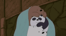 a couple of bears laying on top of each other on a bed under a blanket .