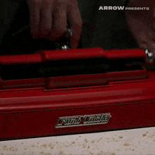 a red crumb catcher with a brush on top of it